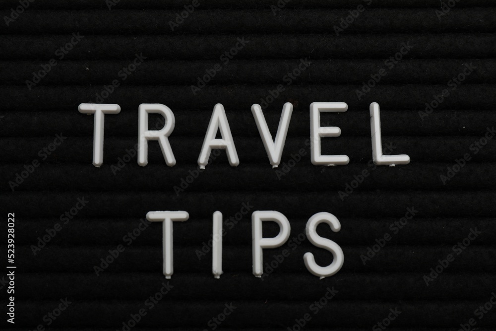 Phrase Travel Tips on black letter board as background, top view Phrase Travel Tips on black letter board as background, top view
