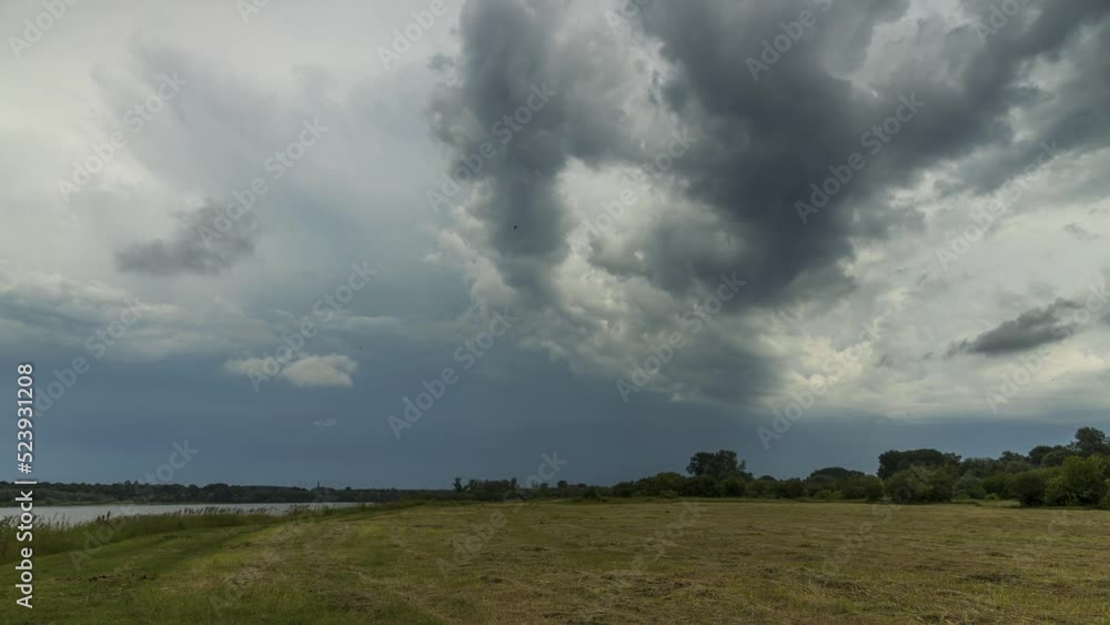 Timelapse of the dramatic clouds passing the meadow and the river Timelapse of the dramatic clouds passing the meadow and the river
