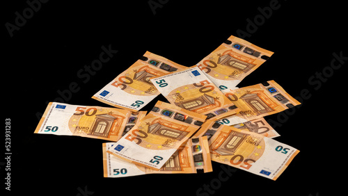 Pile of stacked fifty euro banknotes, on black background. Big plan