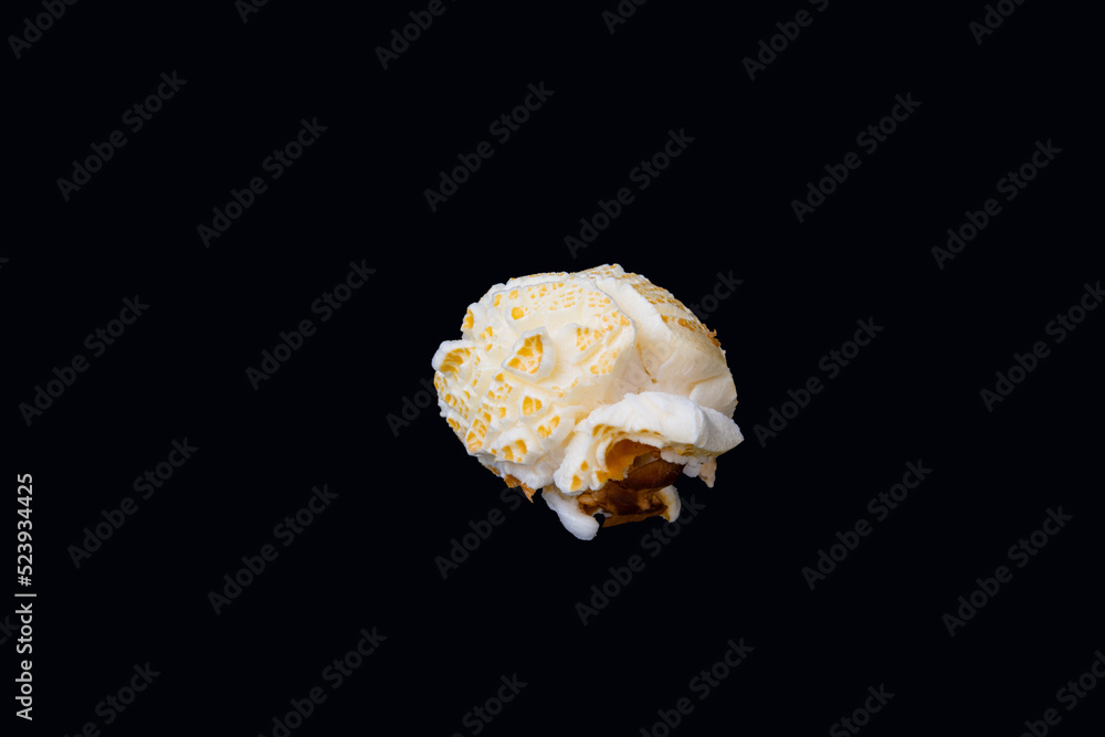 A horizontal photo of an isolated round shaped popcorn with part of the corn husk, an image of round popcorn on a black background. A horizontal photo of an isolated round shaped popcorn with part of the corn husk, an image of round popcorn on a black background.