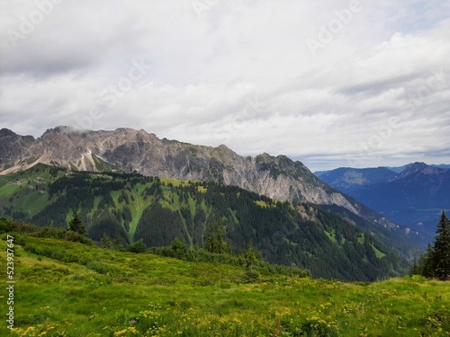 Landscape of beautiful nature with green hills, trees and grass, white clouds in the sky photo