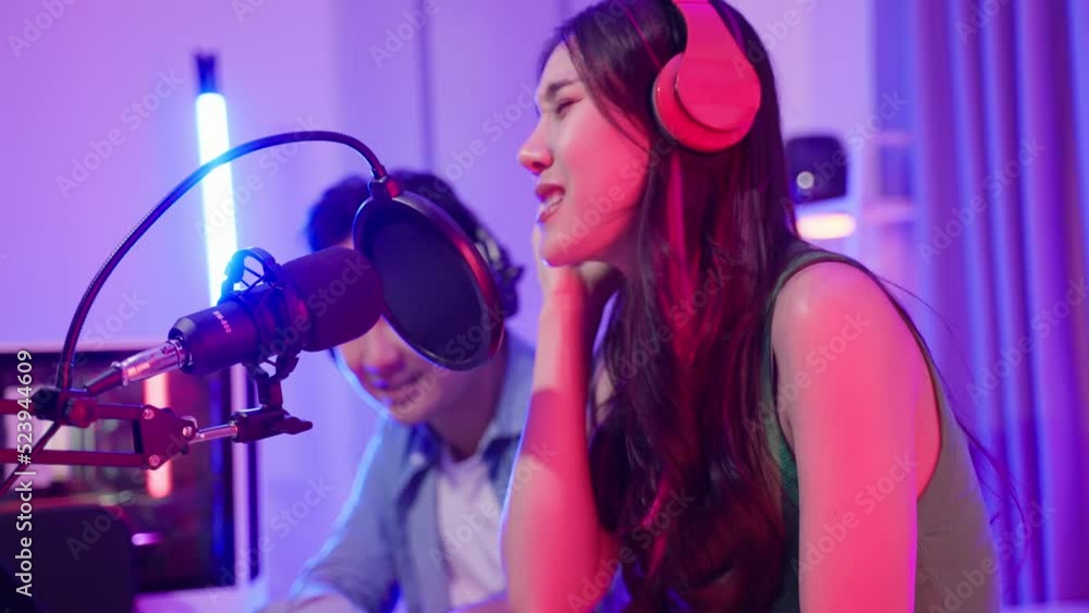 Asian audio DJ man and woman speaks into microphone to broadcasting. Asian audio DJ man and woman speaks into microphone to broadcasting.
