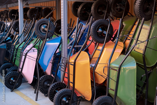Fotografia A lot of New varios color Garden wheelbarrow cart on hardware store, gardening t
