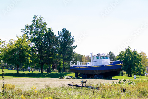 Boat Displayed on Land Near Trees