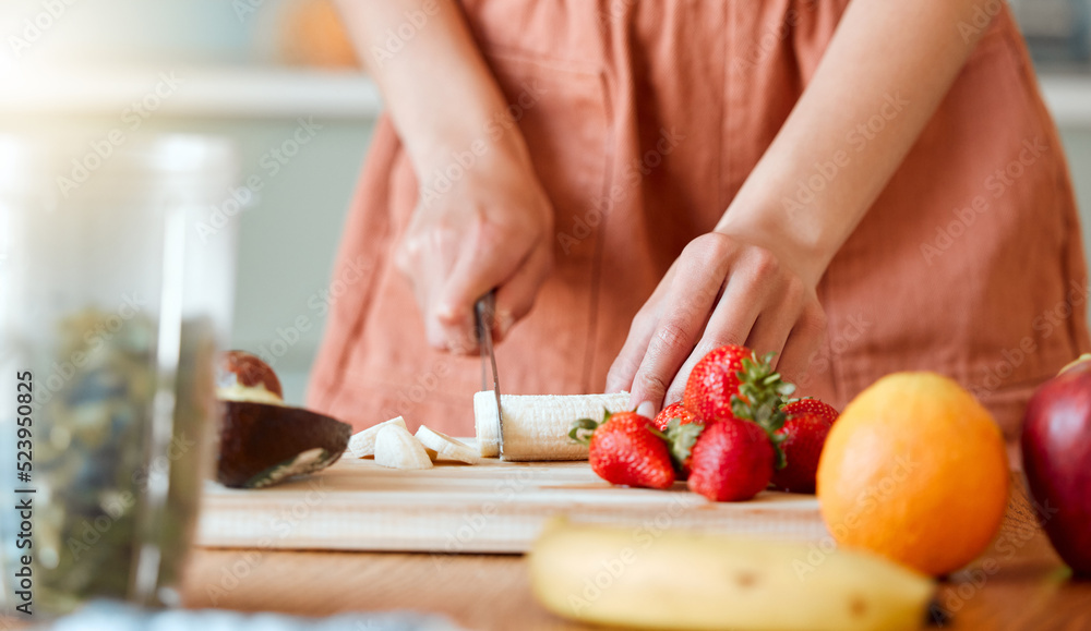 Healthy woman cutting fruit to make a smoothie with nutrition for an organic diet at home. Closeup of caucasian female hands chopping fresh produce for a health drink in a kitchen.