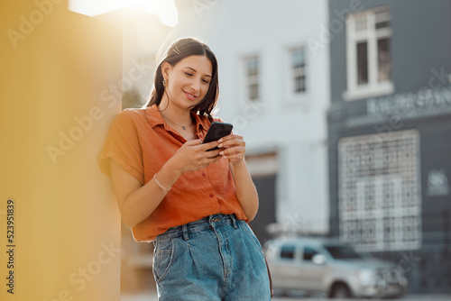 Texting on a phone, waiting for public transport and commuting in the city with a young female tourist enjoying travel and sightseeing. Looking online for places to see and visit while on holiday