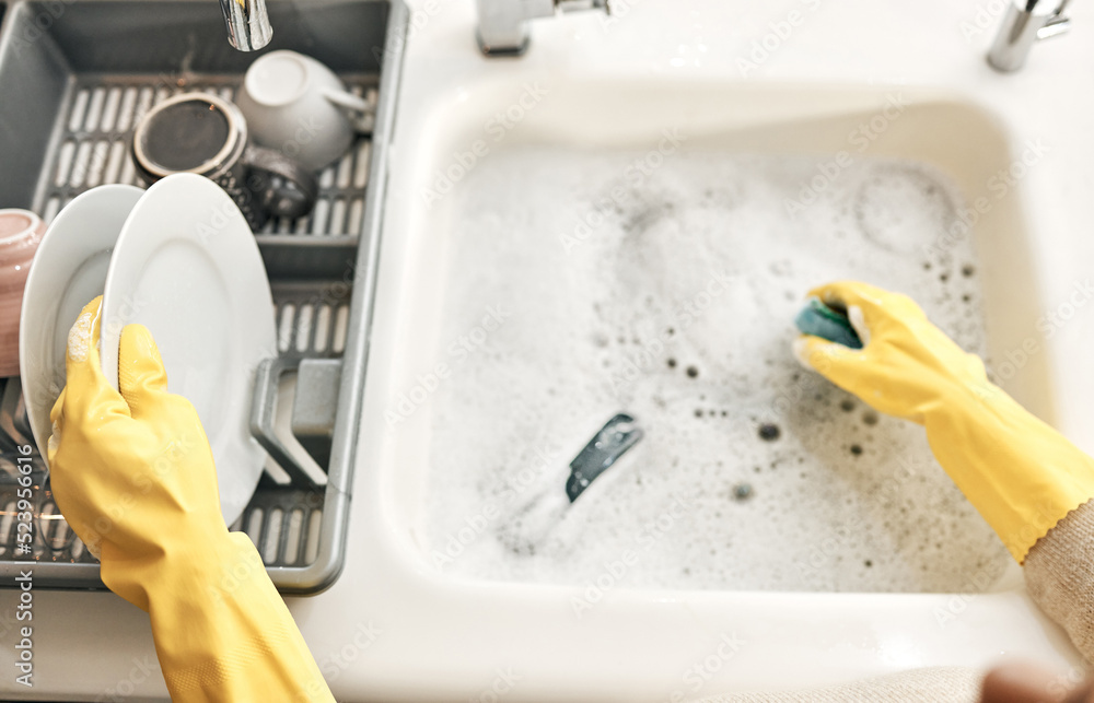 Housewife, maid or cleaner hands washing dishes in the kitchen sink for