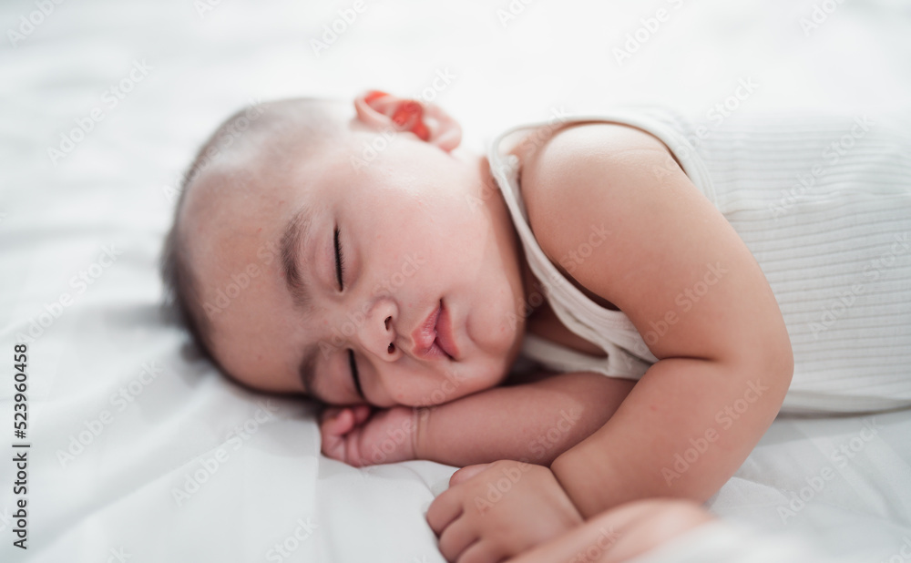 The baby is lovely, sleeping happily and relaxing in bed. The baby is lovely, sleeping happily and relaxing in bed.