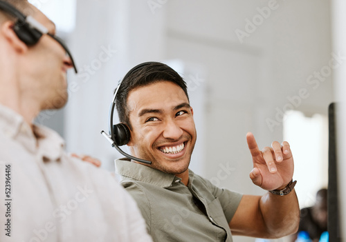 Happy, smiling and laughing call center agent at an insurance company talking to colleague at a help desk. Contact us and our sales customer service support centre and learn about us and thank you photo