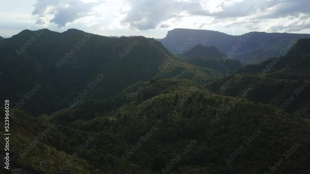 Coromandel Mountains and valley in shadow with the sub behind clouds. Aerial shot. Coromandel Mountains and valley in shadow with the sub behind clouds. Aerial shot.