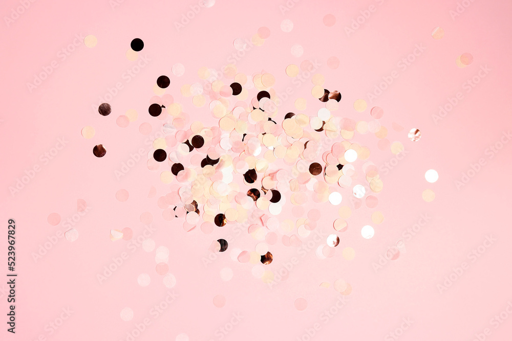 Colorful festive round confetti dots on pink background.