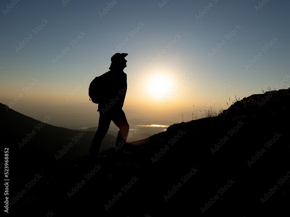 mountaineer hiking at sunrise on summit