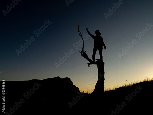 mountaineer successfully climbing a juniper tree photo