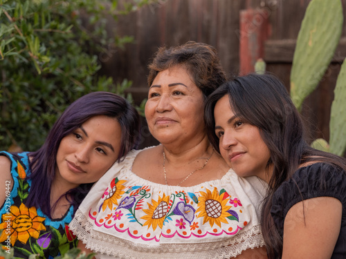 Young Indigenous women leaning their heads on an older Indigenous woman 