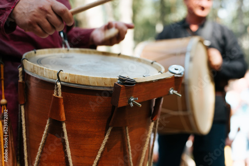 Close-up of a musician playing an ethnic drum with percussion folk music at a traditional medieval outdoor entertainment. Selective focus on percussion