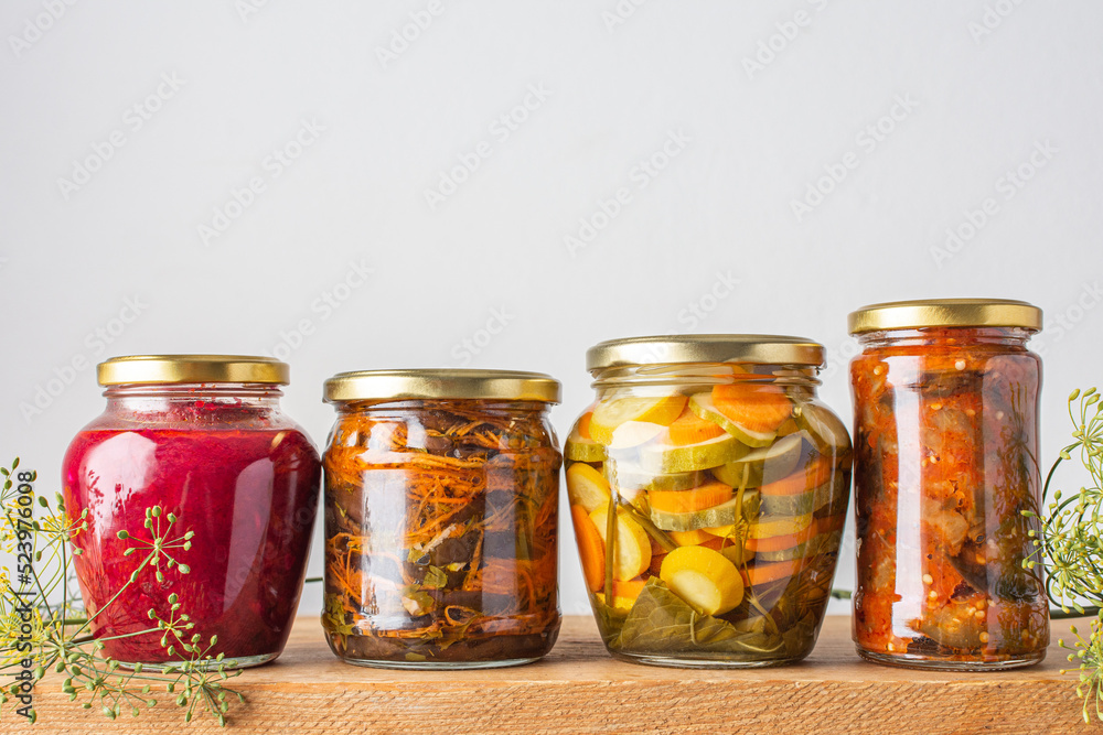 Harvesting vegetables for the winter, canned vegetables in jars on a wooden table, pickled or fermented vegetables, copy space Harvesting vegetables for the winter, canned vegetables in jars on a wooden table, pickled or fermented vegetables, copy space