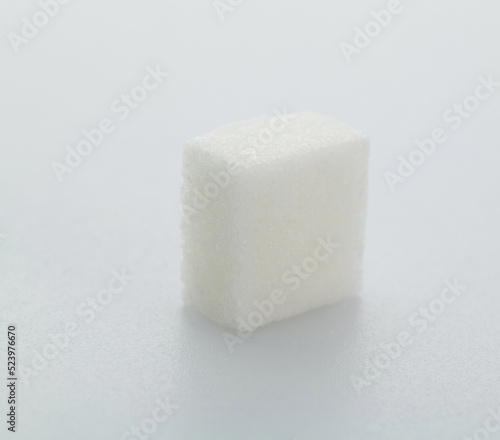One sugar cube on white background
