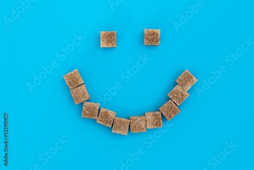 Tablou pe pânză Smile face made of brown sugar cubes