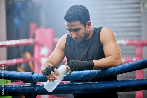 фотографія Sad, lose and defeated athlete looking tired after workout, unhappy and drinking water after boxing for fitness