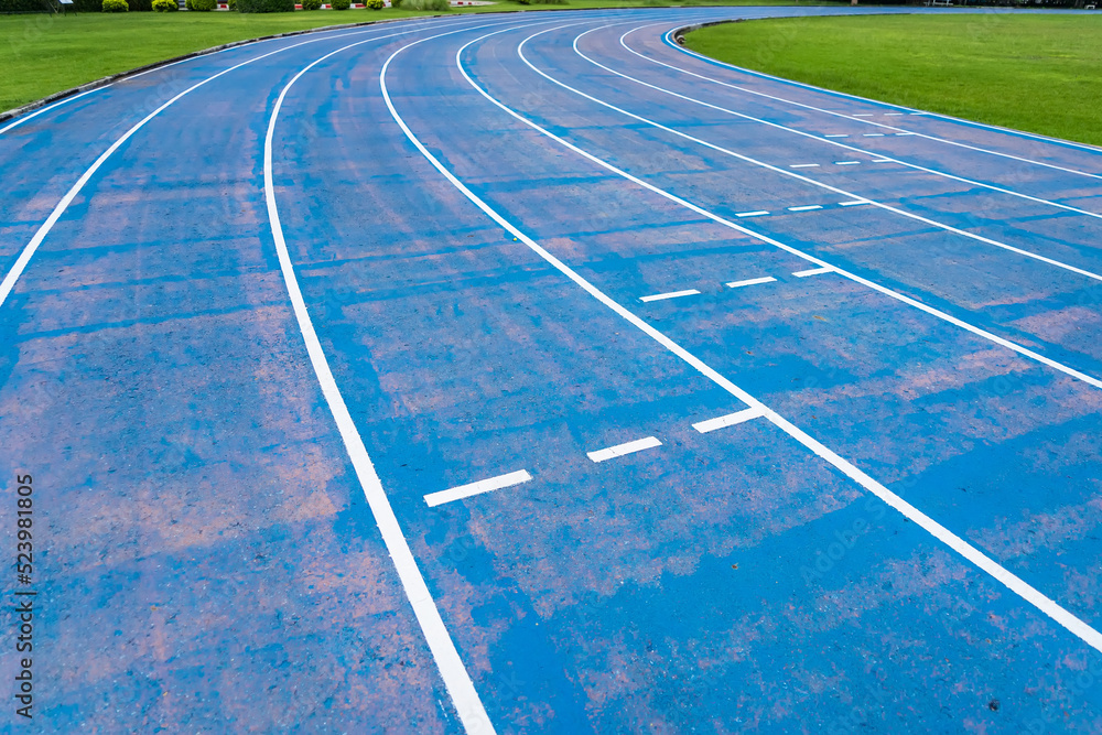 background of blue track for running competition at stadium, focus on center.