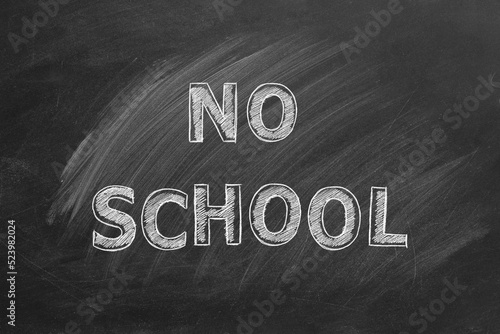 Hand drawn text NO SCHOOL on blackboard.