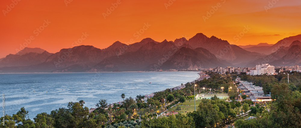 Panoramic cityscape view of Antalya resort town and Taurus mountains in the background during sunset time