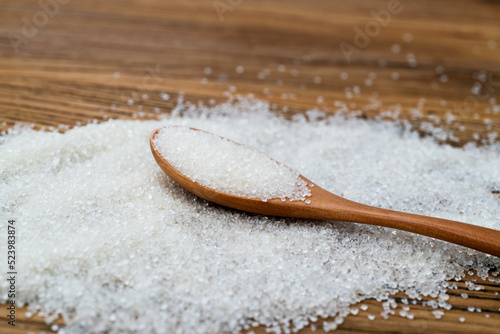 Wooden spoon with sugar crystals on the table
