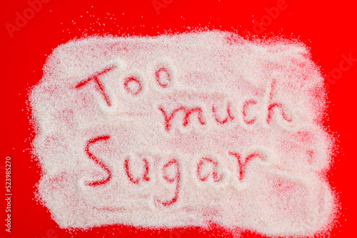Fotografi Text too much sugar written on granulated sugar.