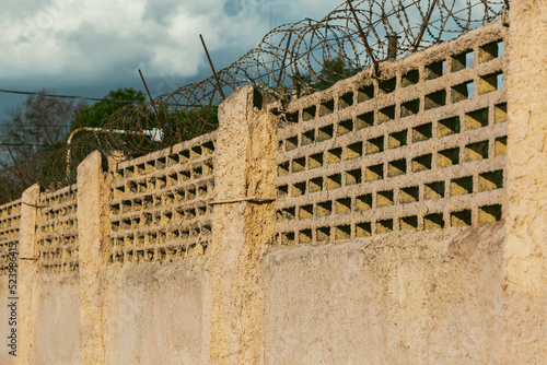 Barbed wire on the background of the sky close-up. Protected area, entrance is prohibited. Danger zone.