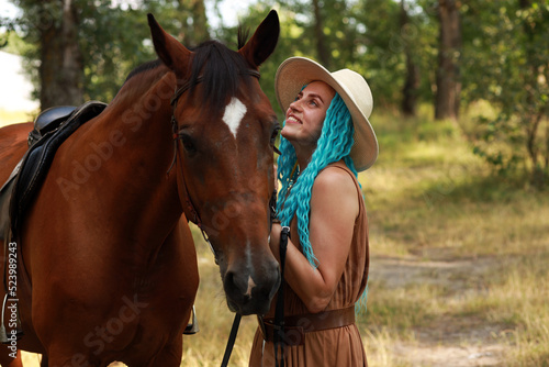 Pretty woman in hat with a horse