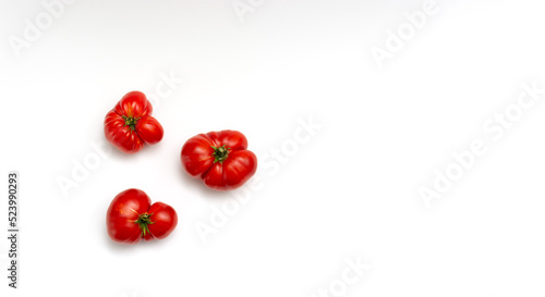 Three unusual tomatoes on a white background. Ugly vegetables.