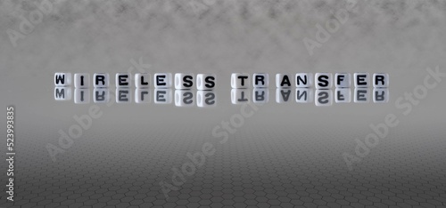 wireless transfer word or concept represented by black and white letter cubes on a grey horizon background stretching to infinity