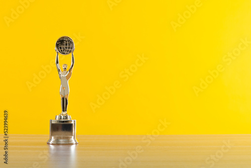 Golden statuette of a man on wooden table photo