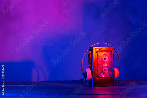 Vintage cassette tape player in neon light. 80s - 90s advertisement style. Disco party nostalgy concept