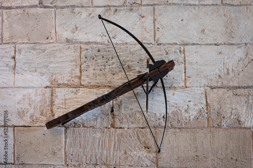 Ancient crossbow weapon hanging on the stone wall of the castle