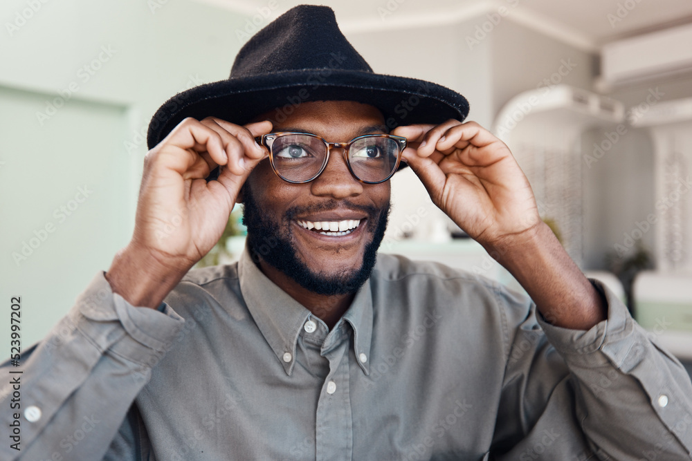 Trendy smiling man wearing glasses buying new eyewear and shopping for new frames at optometrist checkup. Face of a cheerful cool and stylish male fitting frames at an optician office Stock Photo