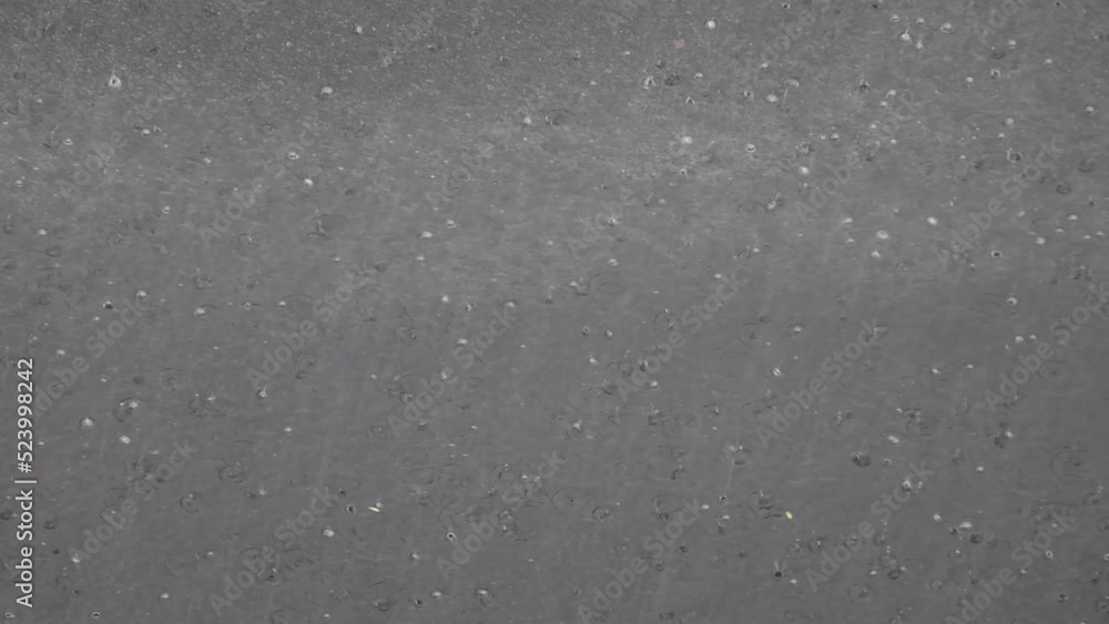 Asphalt road with a puddle during the rain. Spray from passing van on the highway. Asphalt road with a puddle during the rain. Spray from passing van on the highway.