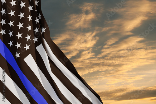 Fotografija American flag with police support symbol Thin blue line on sunset sky