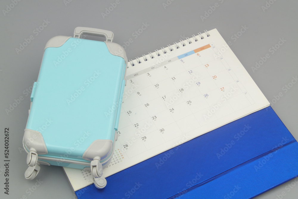Calendar and suitcase on gray background. Calendar and suitcase on gray background.