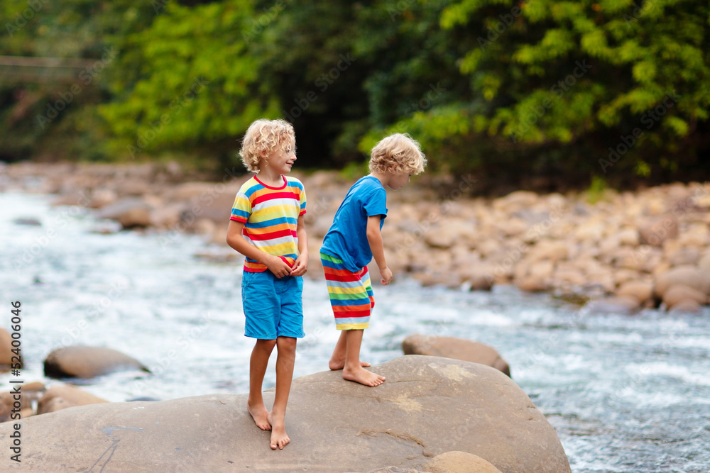 Child hiking in mountains. Kids at river shore. Child hiking in mountains. Kids at river shore.