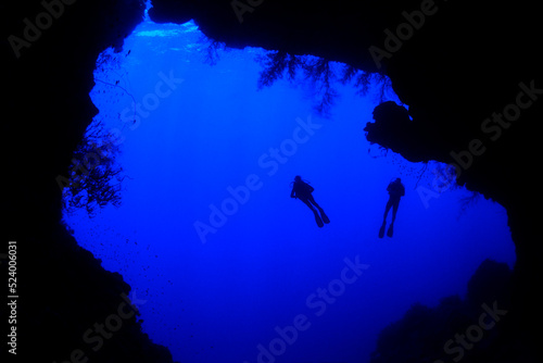 Silhouette of divers exploring underwater cave Red Sea, Egypt. Scanned dia positive image   