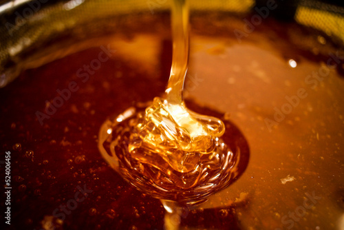Goldener Honig fließt aus Schleuder und bildet Treppchen