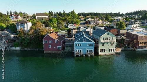 Panning aerial shot of Coupeville's historic business district with multiple buildings hanging out over the water. photo
