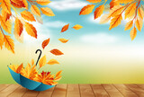 Autumn background with umbrella, flying fall leaves and blue sky