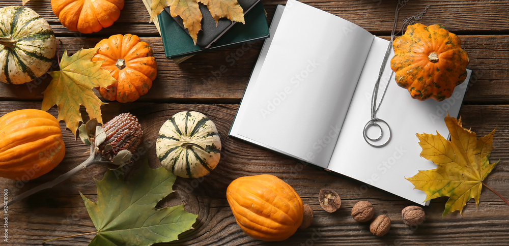 Autumn composition with blank book, jewelry and pumpkins on wooden background, top view