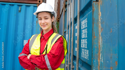 Woman foreman smile Cross her arm in front of Cargo forklift in warehouse , Manager in white helmet Safety Supervisor in Container Custom Terminal port concept import export