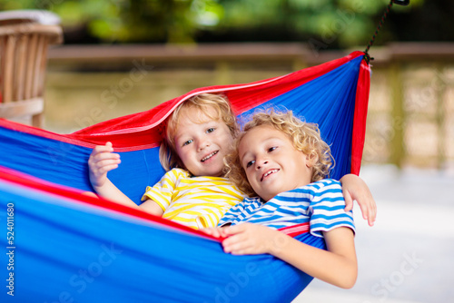 Boy in hammock. Kids play in summer garden.