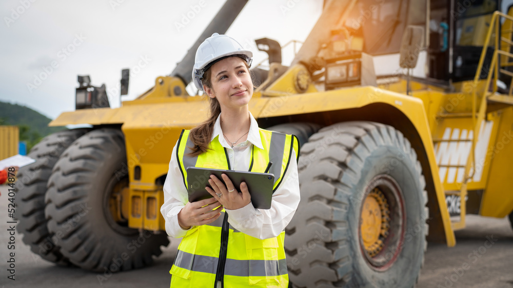 Woman foreman control forklift loading Containers cargo from Truck to port in warehouse , Manager use tablet in white helmet Safety Supervisor in Container Custom Terminal port concept import export