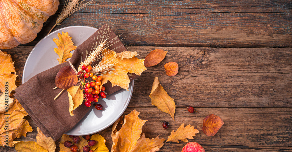 Obraz premium Autumn background with cutlery and autumn leaves on a wooden background. The concept of Halloween, Thanksgiving. Top view