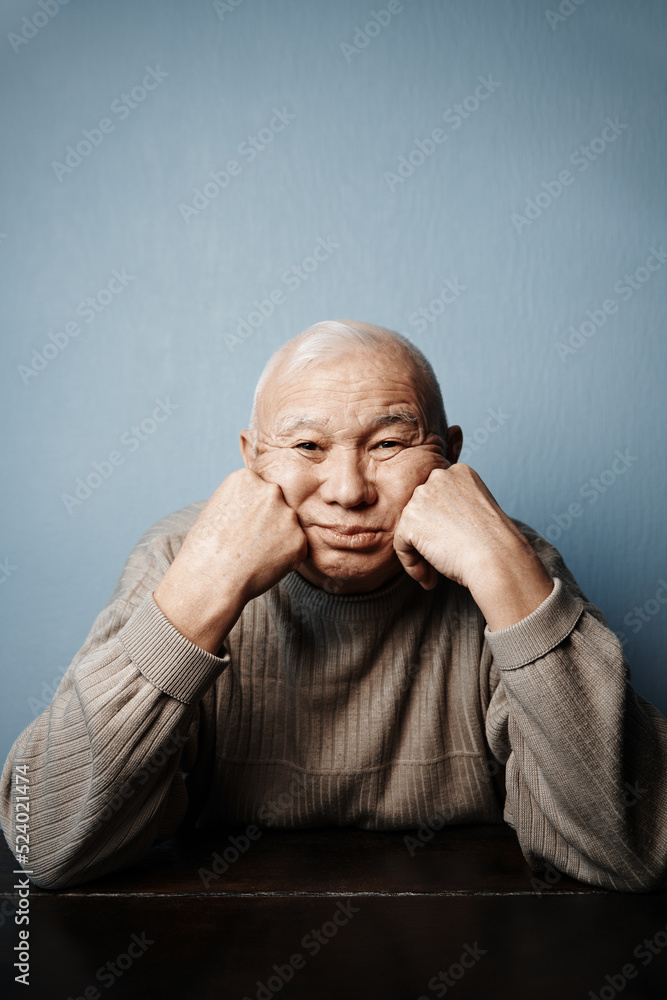 Pensive and thoughtful senior man sitting at the table Pensive and thoughtful senior man sitting at the table